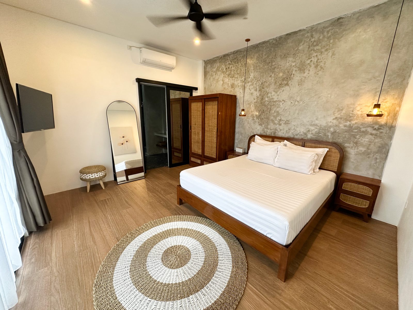Bedroom with rattan bed and concrete feature wall