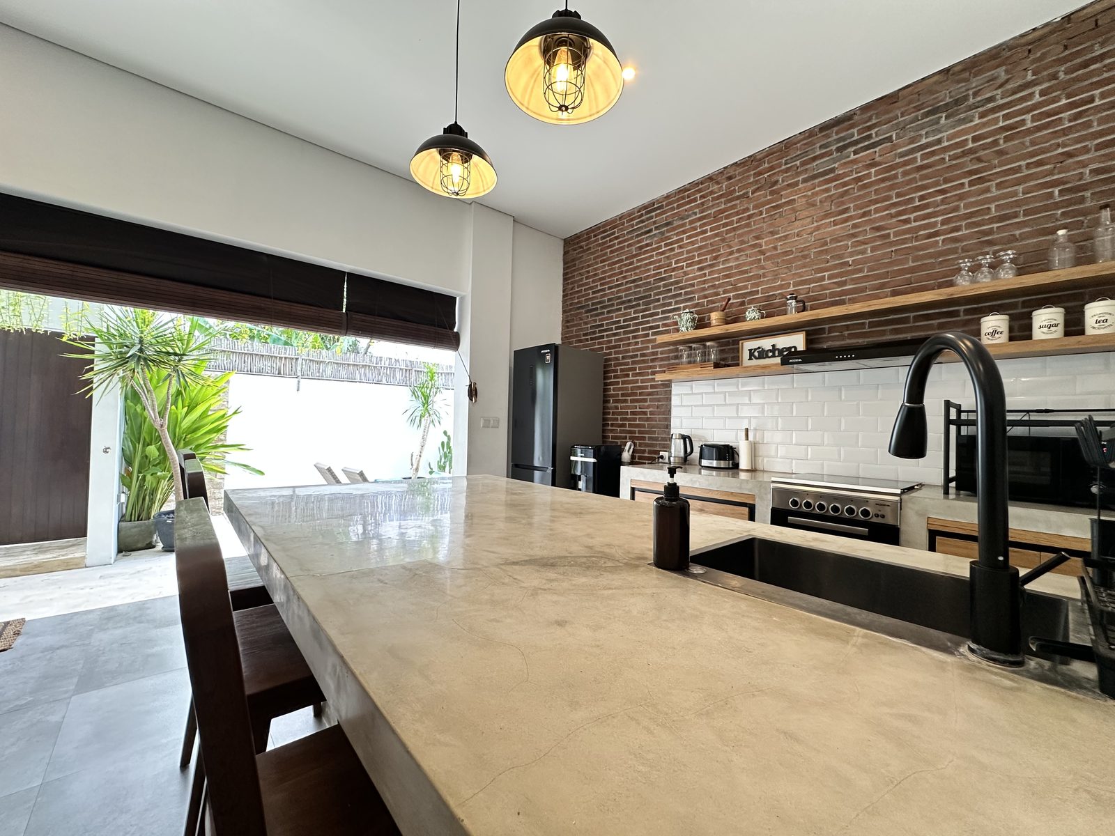 Kitchen with concrete island and exposed brick wall