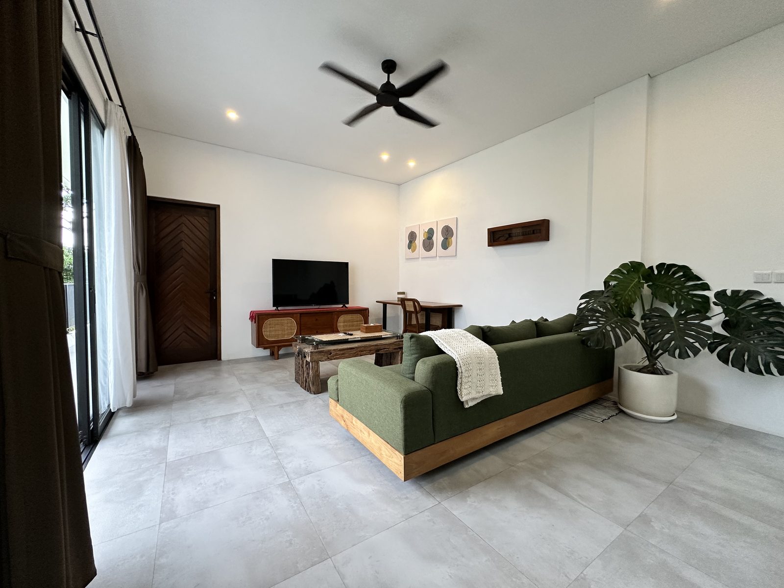 Open-plan living area with green sofa